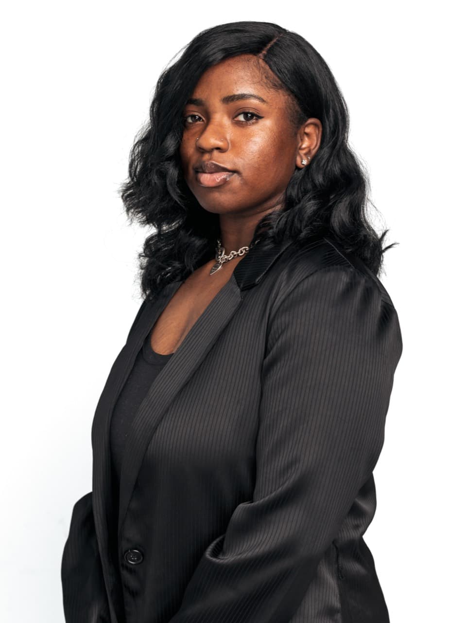 Studio headshot of a woman in a black blazer against a white background